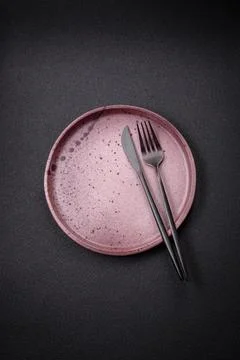 Bumpy empty ceramic plate on a textured concrete background 스톡 사진