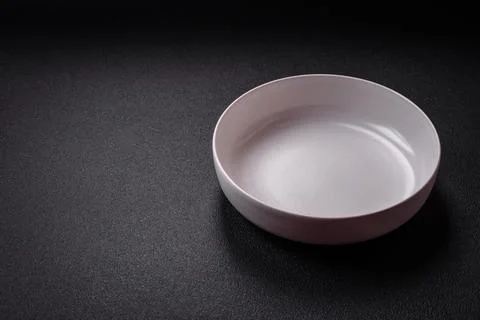 Bumpy empty ceramic plate on a textured concrete background 스톡 사진