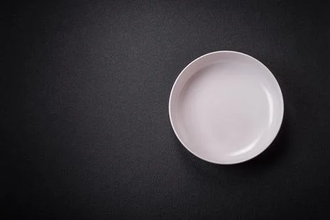 Bumpy empty ceramic plate on a textured concrete background 写真素材