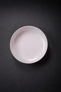 Bumpy empty ceramic plate on a textured concrete background Stock Photos