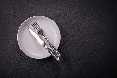 Bumpy empty ceramic plate on a textured concrete background Stock Photos