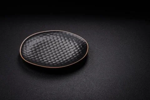 Bumpy empty ceramic plate on a textured concrete background 写真素材