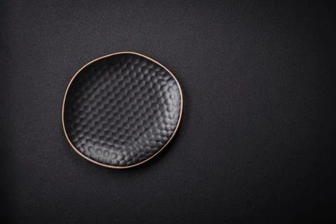 Bumpy empty ceramic plate on a textured concrete background 스톡 사진