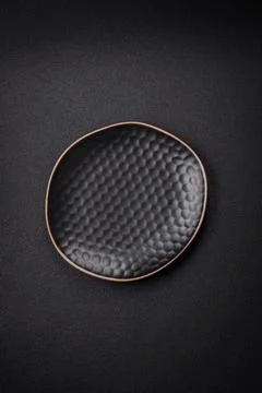 Bumpy empty ceramic plate on a textured concrete background Stock Photos