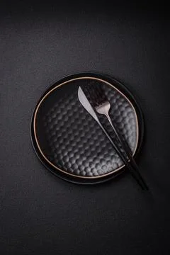 Bumpy empty ceramic plate on a textured concrete background 스톡 사진