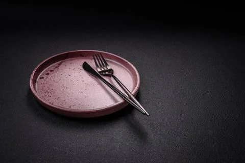 Bumpy empty ceramic plate on a textured concrete background Bumpy empty ce... 스톡 사진