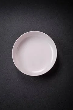 Bumpy empty ceramic plate on a textured concrete background Bumpy empty ce... 스톡 사진