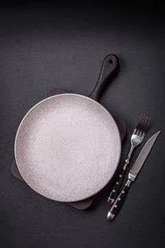 Bumpy empty ceramic plate on a textured concrete background Bumpy empty ce... 스톡 사진