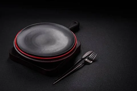 Bumpy empty ceramic plate on a textured concrete background Bumpy empty ce... 스톡 사진