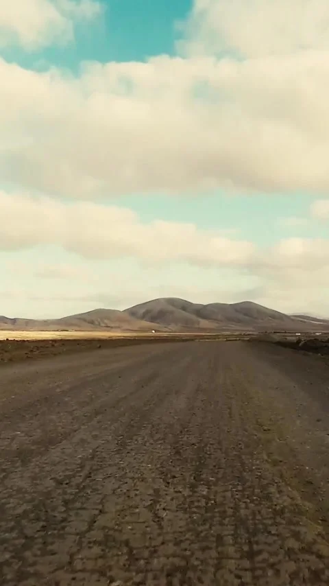 Bumpy ride on a desolate dirt road through a barren landscape towards distant Video stock 344842051