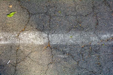 Bumpy road painted white line marking of gray cracked asphalt. Travel concept Stock Photos