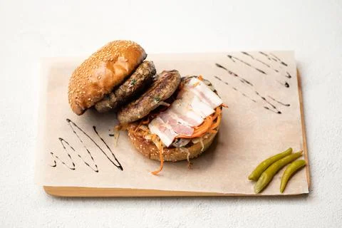 Bun with bacon and two fried cutlets. Double meat burger ingredients. Sandwich Stock Photos