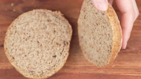 A bun is cut in half, for making a burger or appetizer. The chef puts the h.. Video stock 303977330