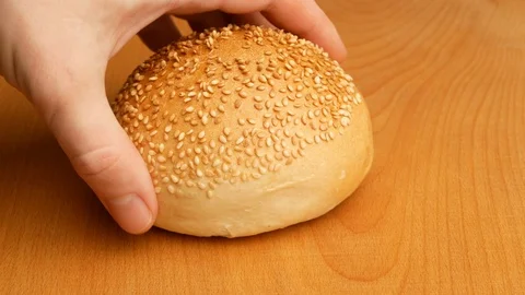 Bun is on the table and then it is taken off the table with his hand. Stock Footage 107620085