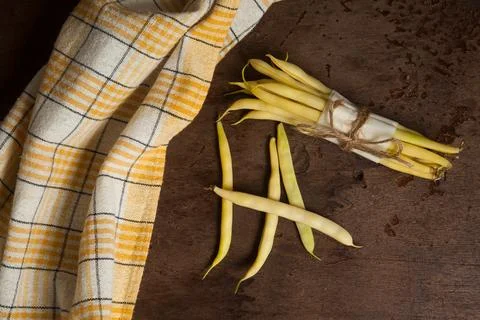 Bunch and several pods of flat runner bean pods heap with yellow kitchen to.. Stock Photos