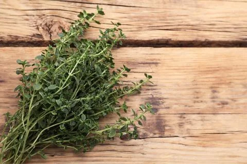 Bunch of aromatic thyme on wooden table, top view. Space for text Stock Photos