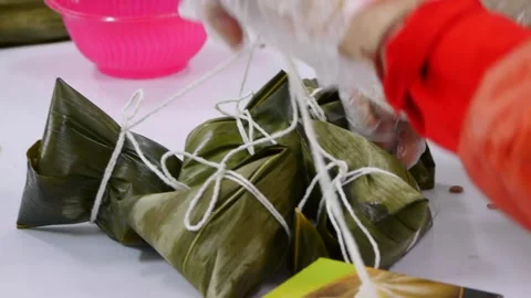 Bunch of Asian rice triangles wrapped in leaf tied together with string Stock Footage 195293575