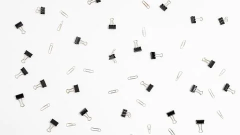 Bunch of binder clips randomly scattered on white background. office equipment Stock Photos