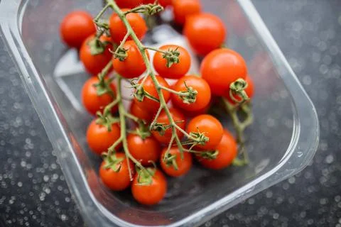 Bunch of cherry tomatoes in a plastic container Foto stock