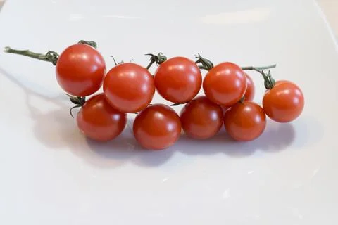 Bunch of cherry tomatoes on a vine Stock Photos