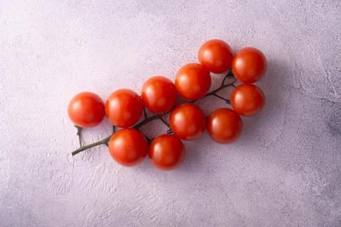 Bunch of cherry tomatoes on white stone concrete table, top view with copy space Stock Photos