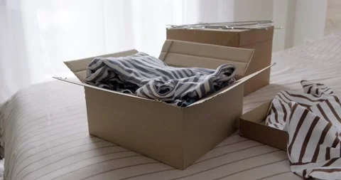 Bunch of clothes being packed in box, donation concept. Video stock 155074038