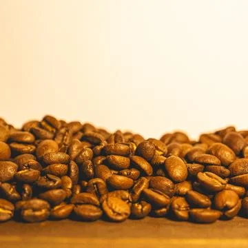Bunch of coffee beans on a table with a light background Stock Photos