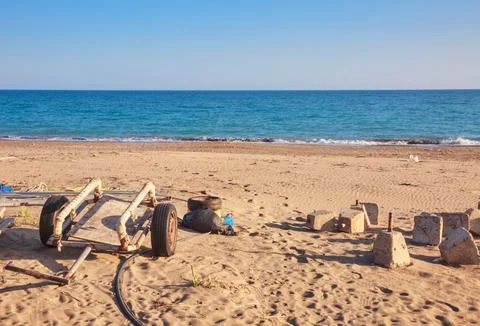 A bunch of different beach garbage on the shore nerthe sea. Stock Photos