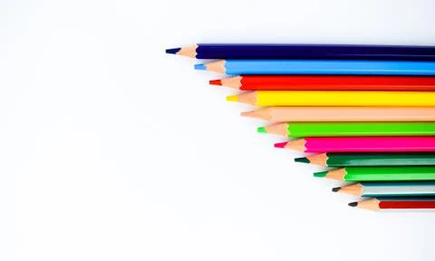 Bunch of different colored pencil crayons arranged from small to big on a whi Stock Photos