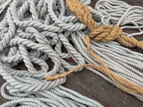 A bunch of different colored strings are tangled together on a wooden surface Stock Photos