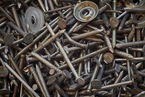 A bunch of different iron construction nails, close-up. Abstract background. Stock Photos