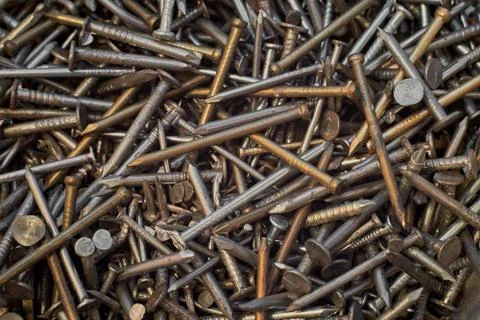 A bunch of different iron construction nails, close-up. Abstract background. Stock Photos