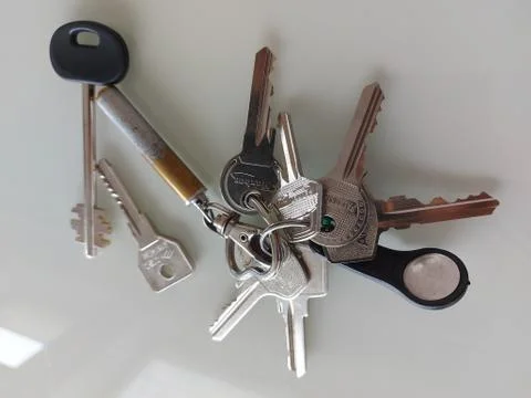 A bunch of different keys on a light surface. Stock Photos