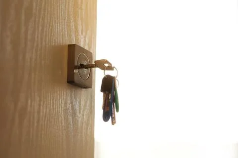 Bunch of different metal keys in lock of new entrance door of house or office Stock Photos