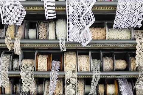 Bunch of different patterned lace borders at a fabric market stall Foto stock