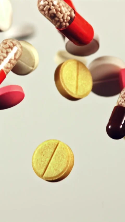 A bunch of different pills fly up and fall down. Filmed on a high-speed camera Stock Footage 335292940