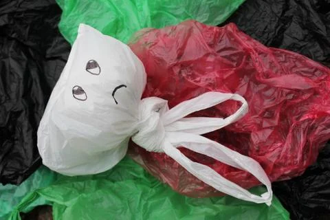 A bunch of disposable, multi-colored plastic bags polluting the environment . Stock Photos