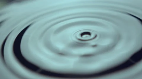 Bunch of drops fall fast and create wave rings on water Stock Footage 232394717