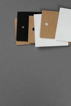 Bunch of five blank tags of white, black and brown colors for clothes with holes Stock Photos