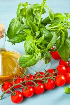 Bunch of fresh basil, tomatoes and olive oil - traditional ingredient of ital Stock Photos