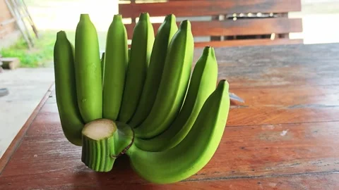 Bunch of fresh green raw bananas on wooden table. Stock Footage 340336862