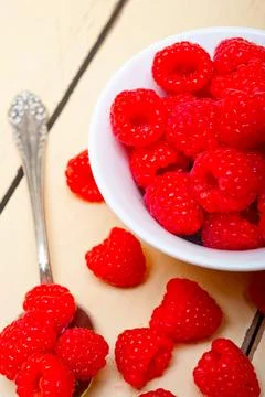 Bunch of fresh raspberry on a bowl and white table Stock Photos