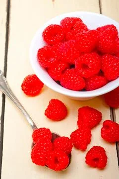 Bunch of fresh raspberry on a bowl and white table Stock Photos