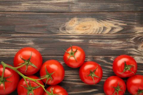 Bunch of fresh tomatoes on brown background. Harvesting tomatoes. Top view Stock Photos