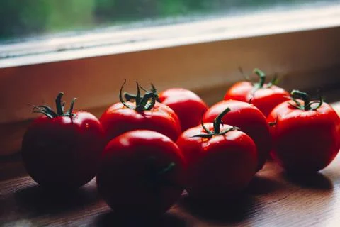 Bunch of fresh tomatoes on the kitchen table by the window Stock Photos