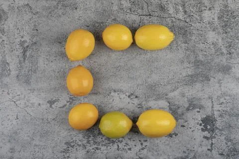 Bunch of fresh yellow lemons placed on stone surface Stock Photos