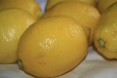 A bunch of fresh yellow lemons on a table. Stock Photos