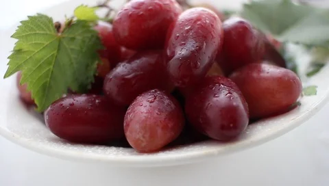 A bunch of grapes close-up on a white table, raindrops Stock Footage 94914696
