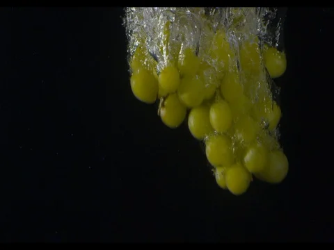 Bunch of green grapes diving into the water at the left side of the shot Stock Footage 74193023