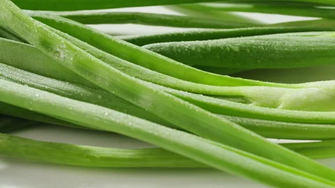 Bunch of green onion feathers with drops of water on a cutting board, Close-up Stock Footage 242521979